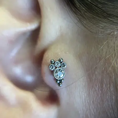Perforación de tragus con cluster de piedras redondas y ajuste perfecto - Laura Blu Bonanova