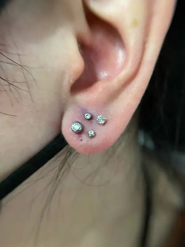 Constelación de 4 piercings en el lóbulo formando un rombo con zirconitas - Bonanova